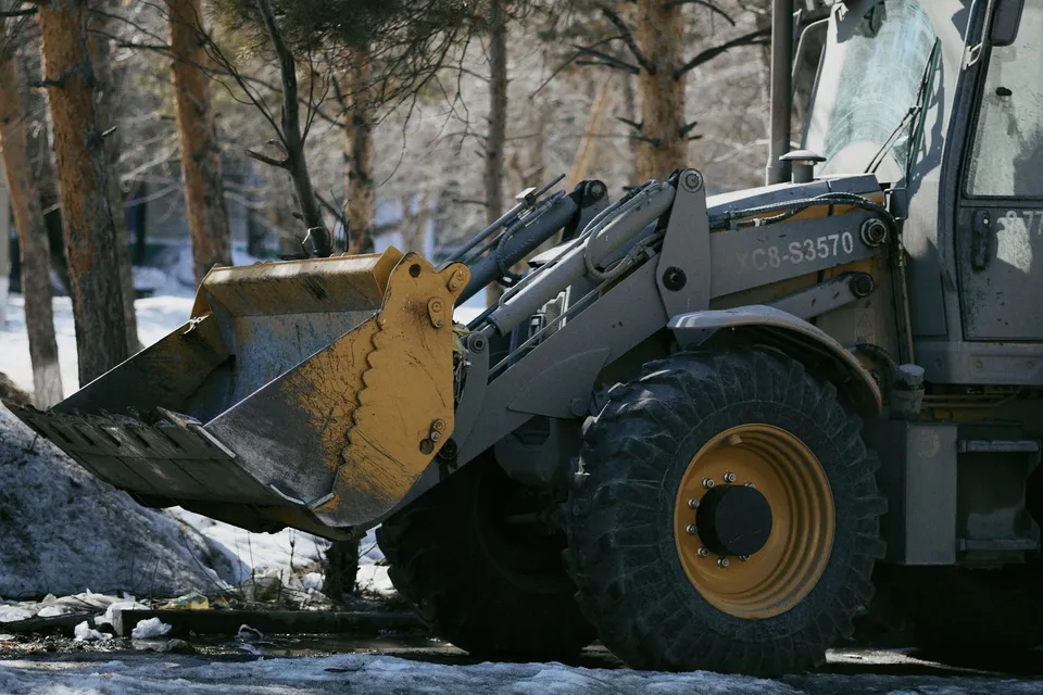Heavy-duty excavator in a snowy forest, ideal for winter construction themes.